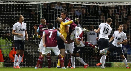 West Ham's Andy Carroll fouling both David De Gea and Patrice Evra of Manchester United during the Barclays Premier League match between West Ham United and Manchester United in Upton Park, London on April 17, 2013.