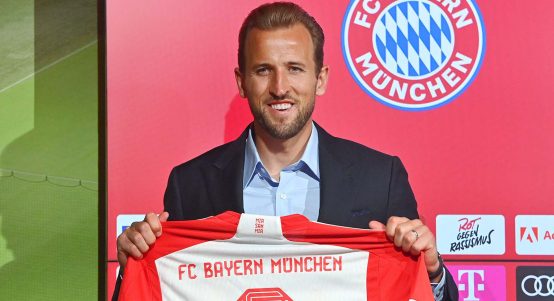 Bayern Munich's new player Harry Kane holds up a shirt at a press conference at the Allianz Arena