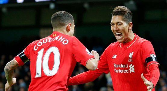 Liverpool’s Roberto Firmino celebrates with teammate Liverpool’s Philippe Coutinho