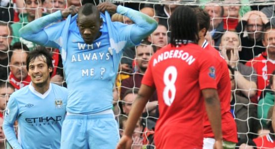 Mario Balotelli celebrates scoring against Manchester United by revealing a t-shirt with 'Why Always Me?' written on it.