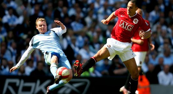 Manchester United's Rio Ferdinand is tackled by Manchester City's Michael Ball at City of Manchester Stadium, Manchester, May 2007.