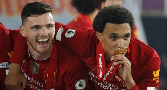 Liverpool's Trent Alexander-Arnold, right with Liverpool's Andrew Robertson, pose for the cameras following the presentation of the English Premier League trophy, Anfield, Liverpool, July 2020.